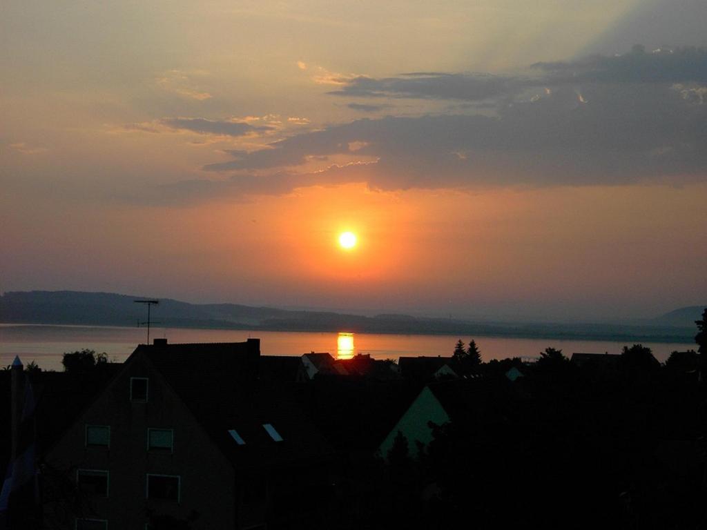 a sunset over the water with the sun in the sky at Haus Traumblick in Pleinfeld