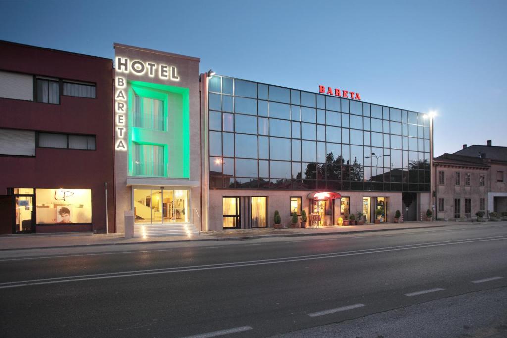 un hotel con una señal verde en la parte delantera de un edificio en Hotel Bareta, en Caldiero