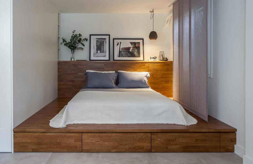 Schlafzimmer mit einem großen Bett mit einem Kopfteil aus Holz in der Unterkunft BRAND NEW apartment below the ACROPOLIS in Athen
