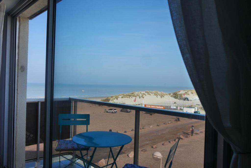 a view of the beach from a room with a balcony at La Timonerie - La Caraque 35, vue mer et dunes classé 2 étoiles in Fort-Mahon-Plage