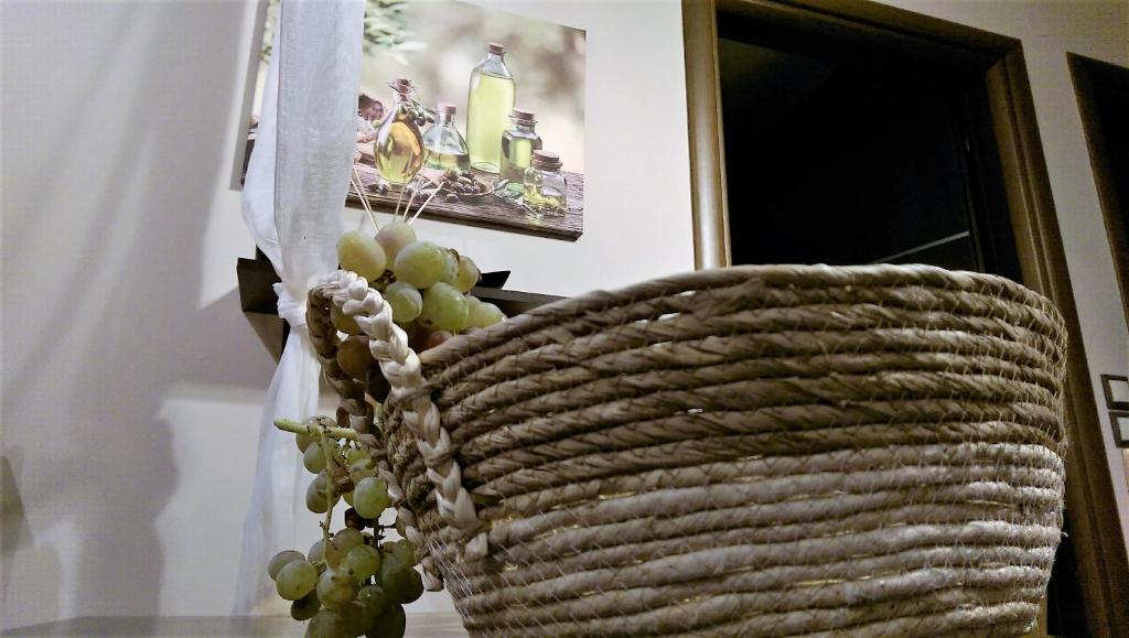 a basket filled with green grapes next to a door at Maria's Rose Garden in Lefkada Town