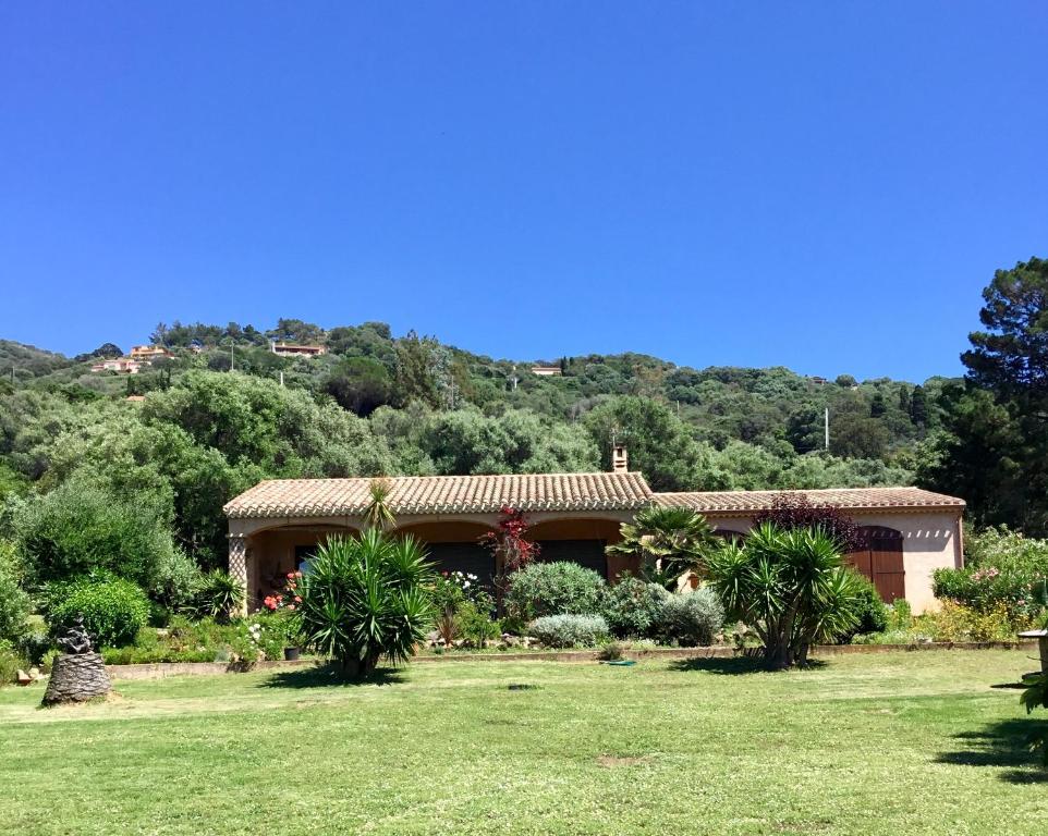 ein Haus auf einem Feld mit Bäumen im Hintergrund in der Unterkunft A CASA DI MAMMÓ in Cargèse