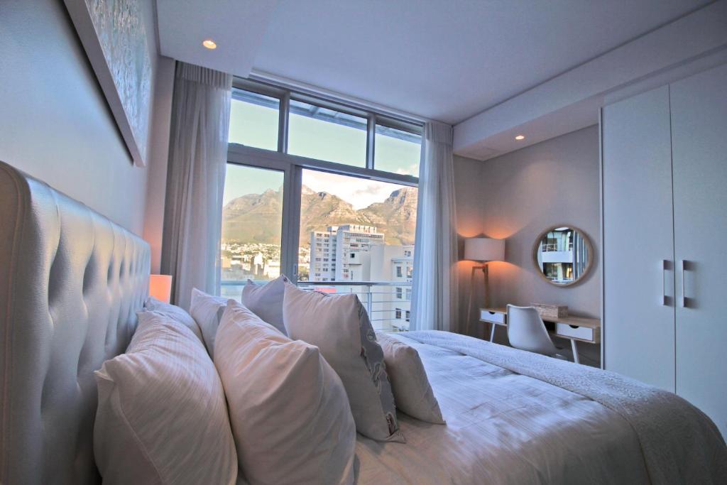 a bedroom with a large bed with a large window at Sensational Sentinel in Cape Town