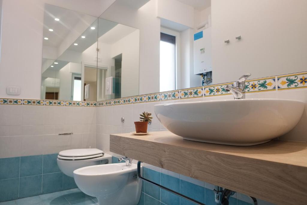 bagno con lavandino, servizi igienici e specchio di Smeraldo a Maiori