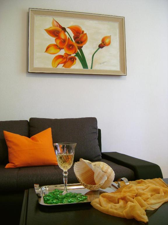 ein Wohnzimmer mit einer Couch und einem Tisch mit einem Weinglas in der Unterkunft Apartment Veronica in Split