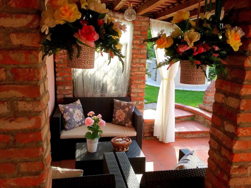 eine Terrasse mit 2 Stühlen und einem Tisch mit Blumen in der Unterkunft Amaryllis Case Vacanza in Il Romito