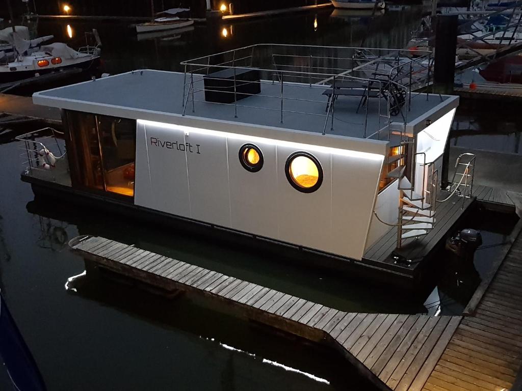 Ein Boot liegt an einem Dock im Wasser. in der Unterkunft Riverloft I in Cuxhaven