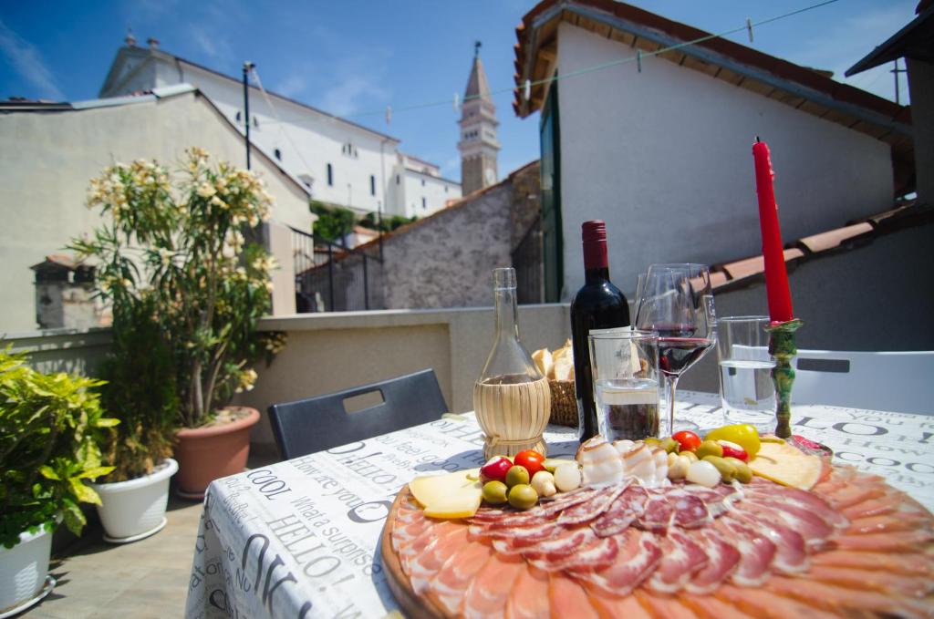 una mesa con copas de vino y un plato de comida en Traditional Piran house, en Piran