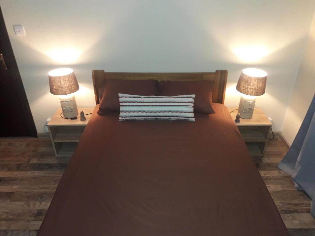 een bed met twee lampen op twee nachtkastjes bij Majo's Appart in Rivière Noire