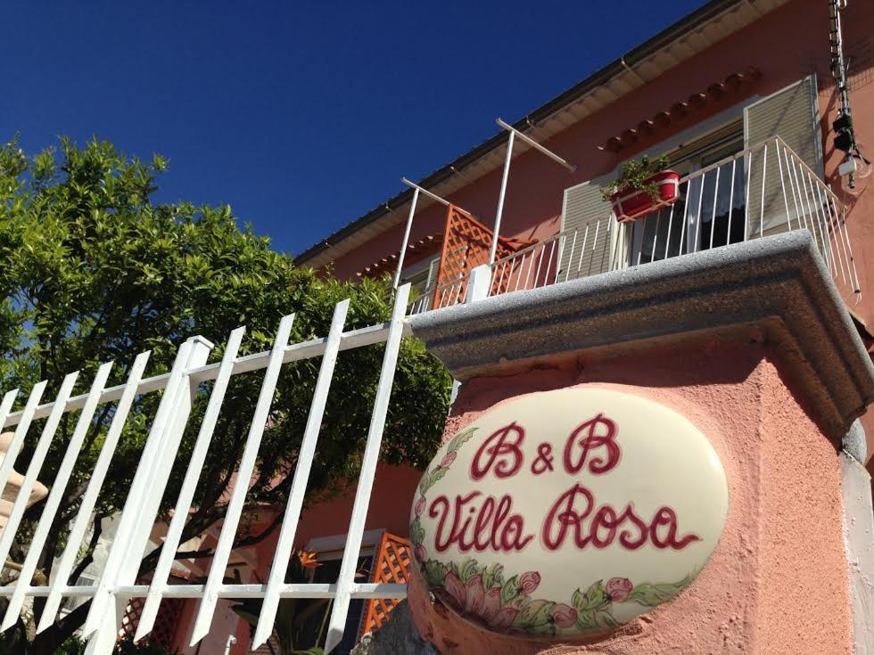 un edificio rosa con un cartel de pizza ailla en B&B Villa Rosa Angrisano, en Maratea