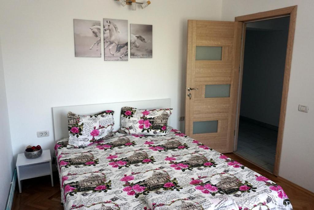een slaapkamer met een bed met roze bloemen erop bij La Alina in Eforie Sud