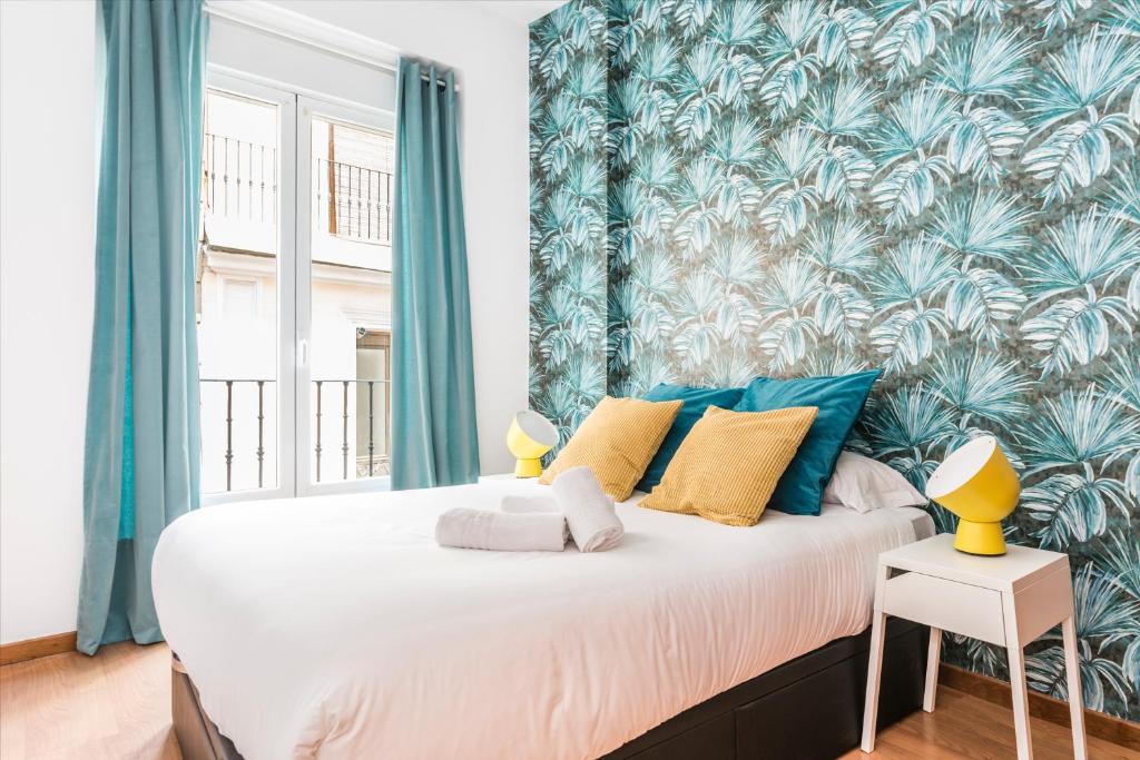 マドリードにあるBNBHolder Plaza de Luna MALASAÑAのベッドルーム1室(青いカーテン付きの大型ベッド1台付)