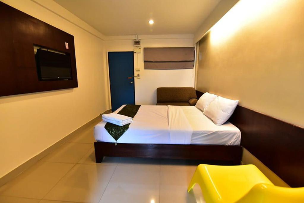 Habitación de hotel con cama y silla amarilla en L42 Hostel Suvarnabhumi Airport, en Lat Krabang
