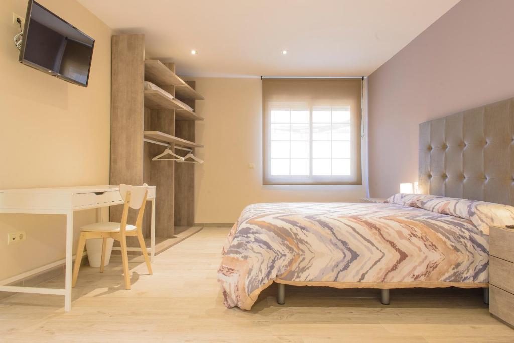 a bedroom with a bed and a desk and a table at Vive Tarragona in Tarragona