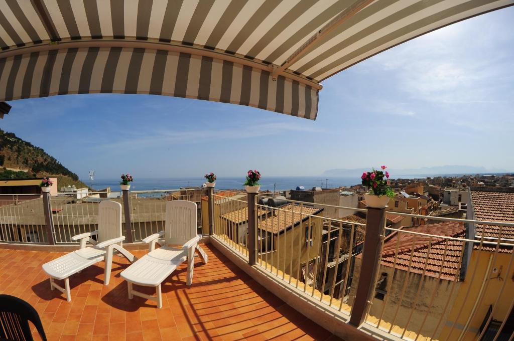 balcone con sedie bianche e vista sull'oceano di Le Sette Meraviglie a Castellammare del Golfo