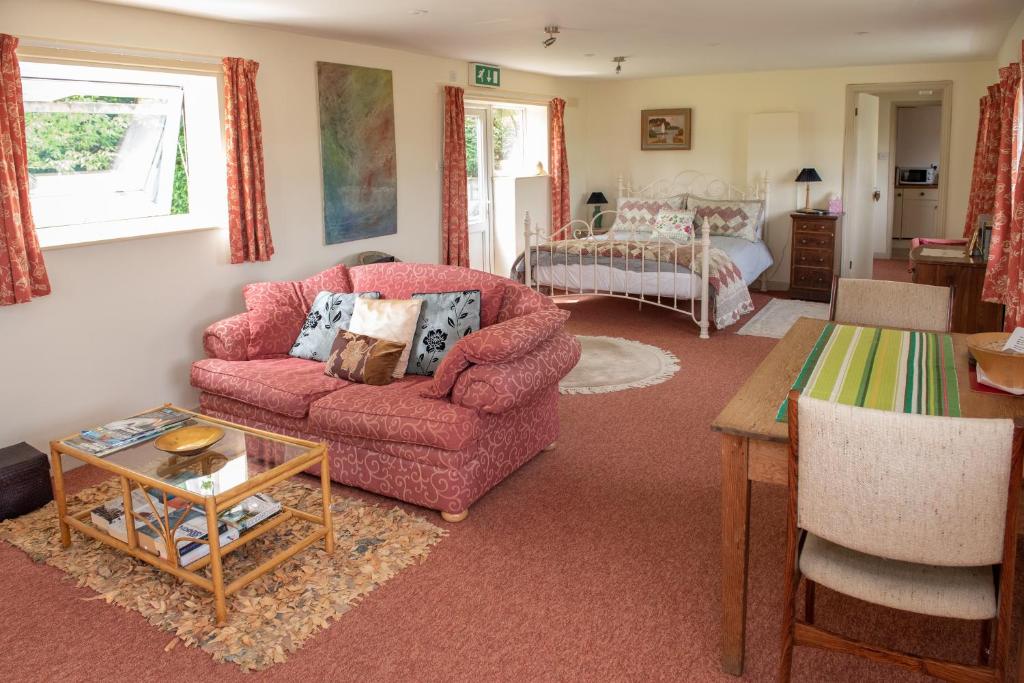 a living room with a pink chair and a table at The Studio in Somerton