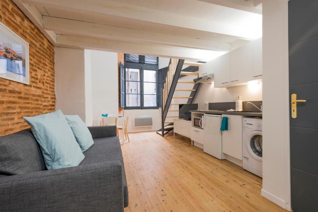 un salon avec un canapé et une cuisine dans l'établissement Daurade, à Toulouse