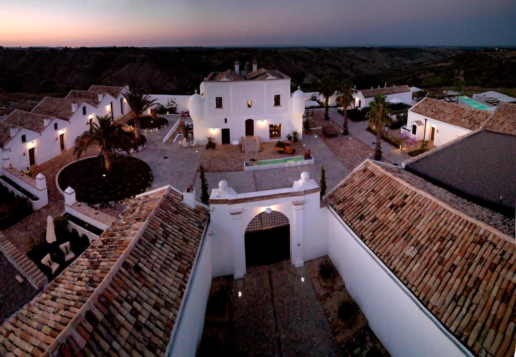 una vista aérea de un edificio con una puesta de sol en el fondo en Torre Fiore Hotel Masseria, en Pisticci