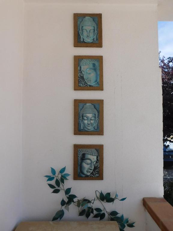 uma parede com quatro fotos de rostos nela em Cabanas2 em Cabanas de Tavira