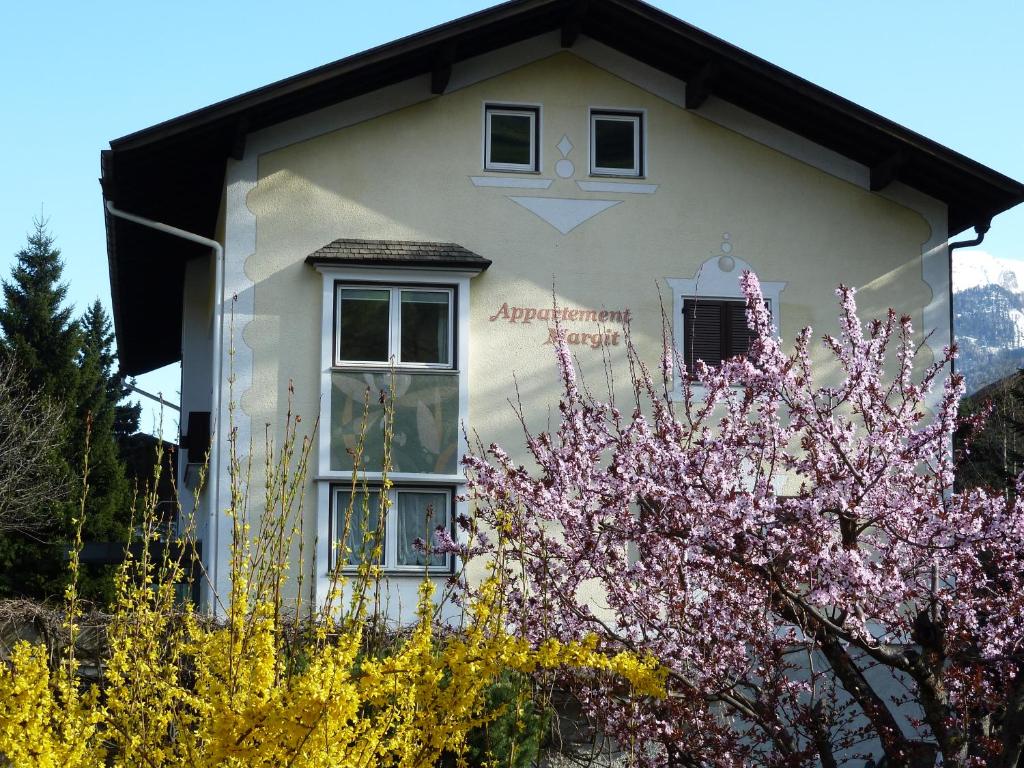 uma casa com uma árvore florida em frente em Appartements Margit em Vipiteno