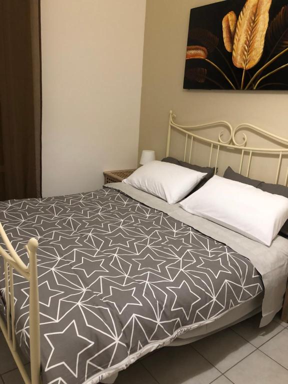 Schlafzimmer mit einem Bett mit einer schwarzen und weißen Bettdecke in der Unterkunft A casa di Flavia in Catania