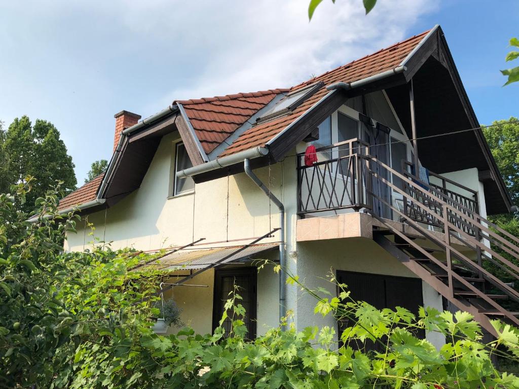 a house with a balcony and a person on the balcony at Liget apartman in Balatonföldvár