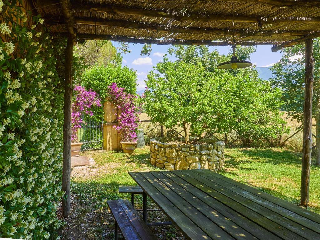 a wooden bench sitting under a pergola with a tree at Cottage del Limone in Spoleto
