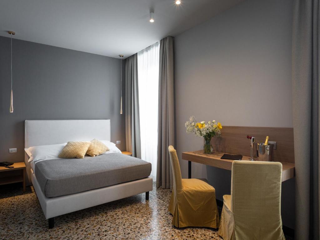 una camera con letto, scrivania e tavolo di HNN Luxury Suites a Genova