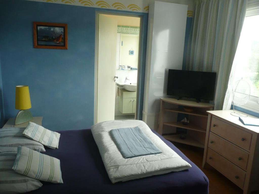 プレスタン・レ・グレーヴにあるResidence les cotes d'Armorの青いベッドルーム(ベッド1台、テレビ付)