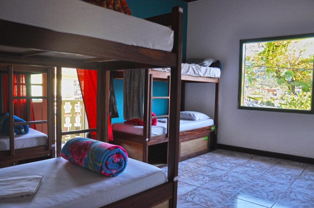 a room with three bunk beds and a window at Vibe Hostel Paraty in Paraty