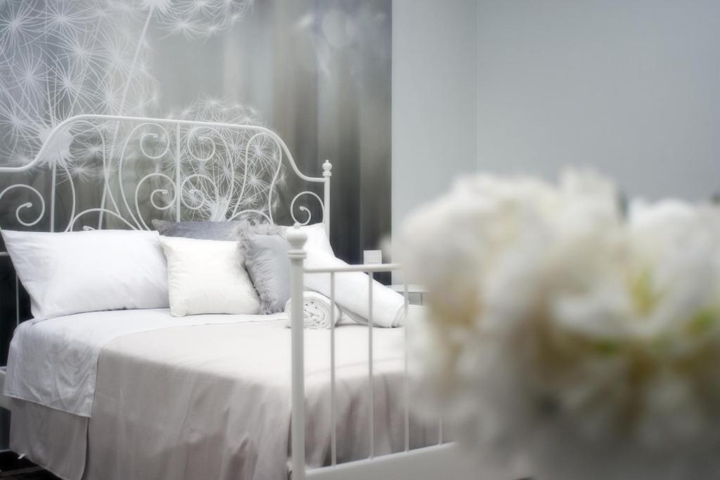 a bedroom with a white bed with white sheets and pillows at Pompei TERAFI Home in Pompei