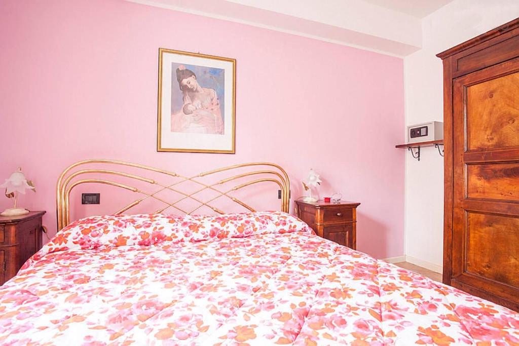 a bedroom with a bed with a floral bedspread at Residenza "Il Torrazzo" in Cremona