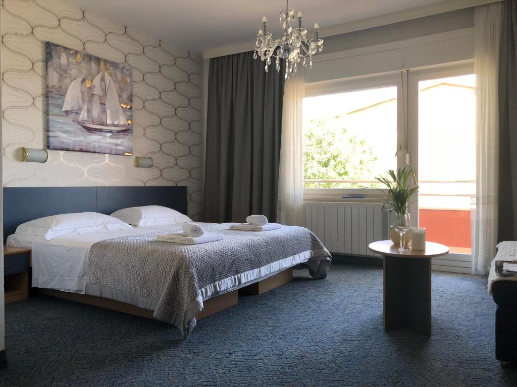 1 dormitorio con cama y lámpara de araña en Rooms Ana en Split