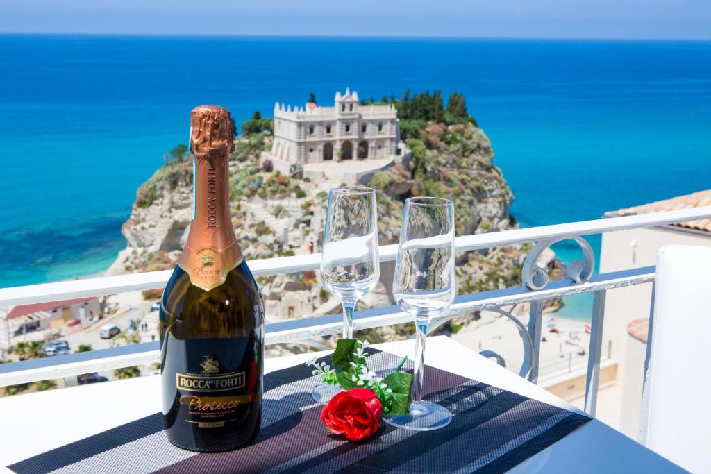 a bottle of champagne and two wine glasses on a table at Sunset Tropea in Tropea