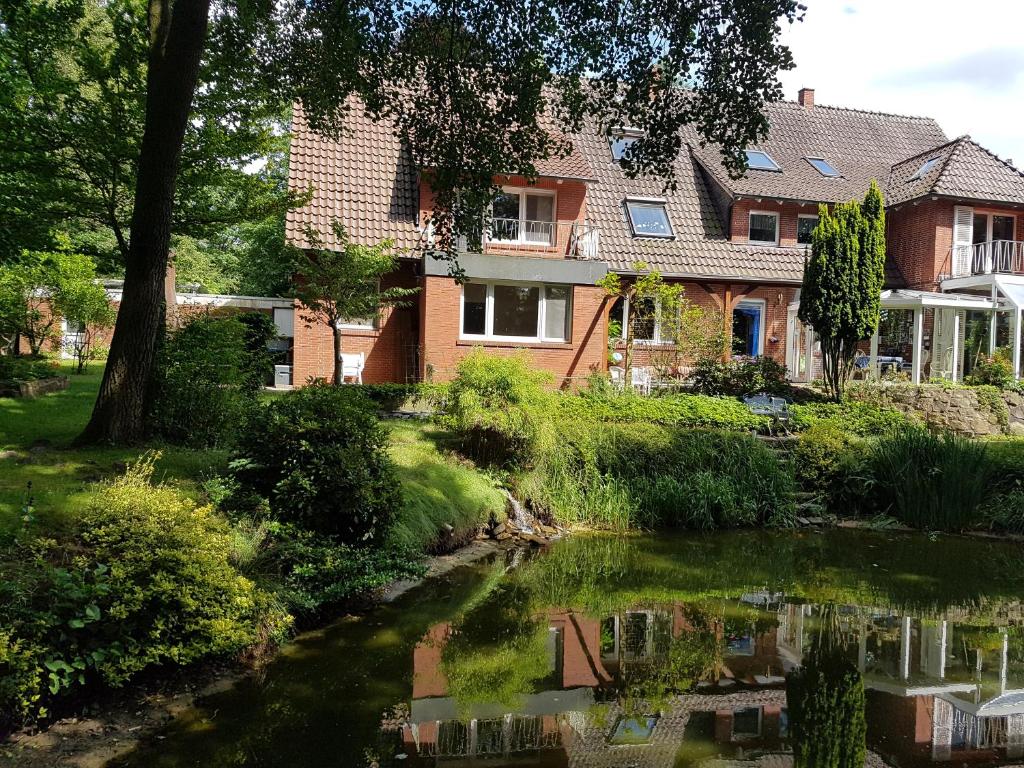 a house and a pond in front of a house at B&B Dersum Dream in Dersum