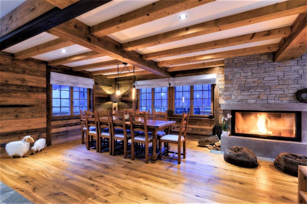 a dining room with a fireplace and a table and chairs at Chalet le Petou in Champéry