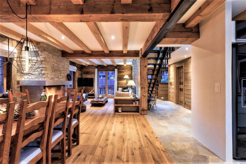 a living room with a fireplace and wooden ceilings at Chalet le Petou in Champéry