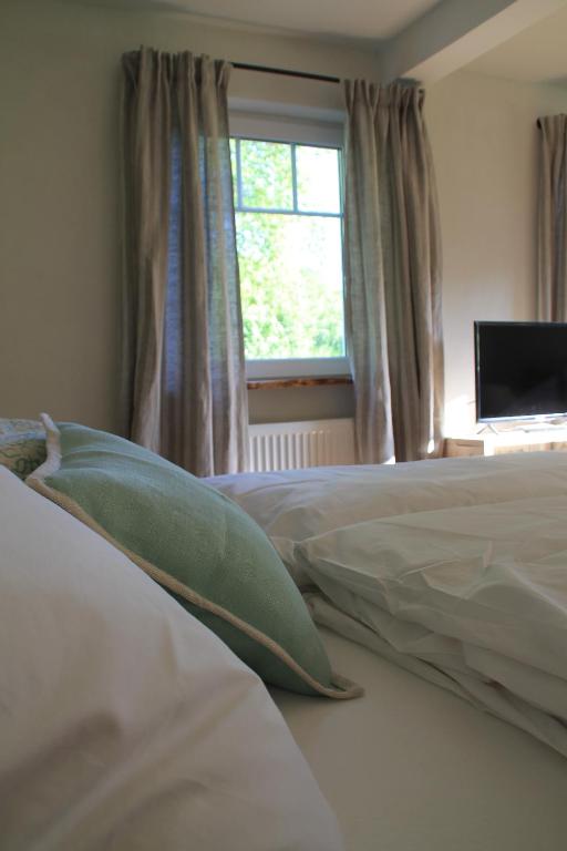 Schlafzimmer mit einem Bett mit einem Fenster und einem TV in der Unterkunft Tauber Lodge in Creglingen