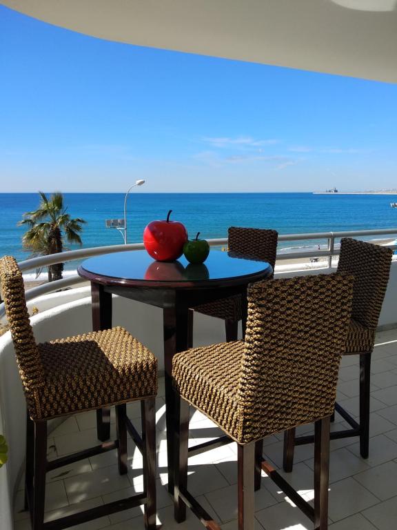 a table with an apple and two chairs on a balcony at Villa Venecia, Apartamento de Lujo en 1º línea de playa + parking in Málaga
