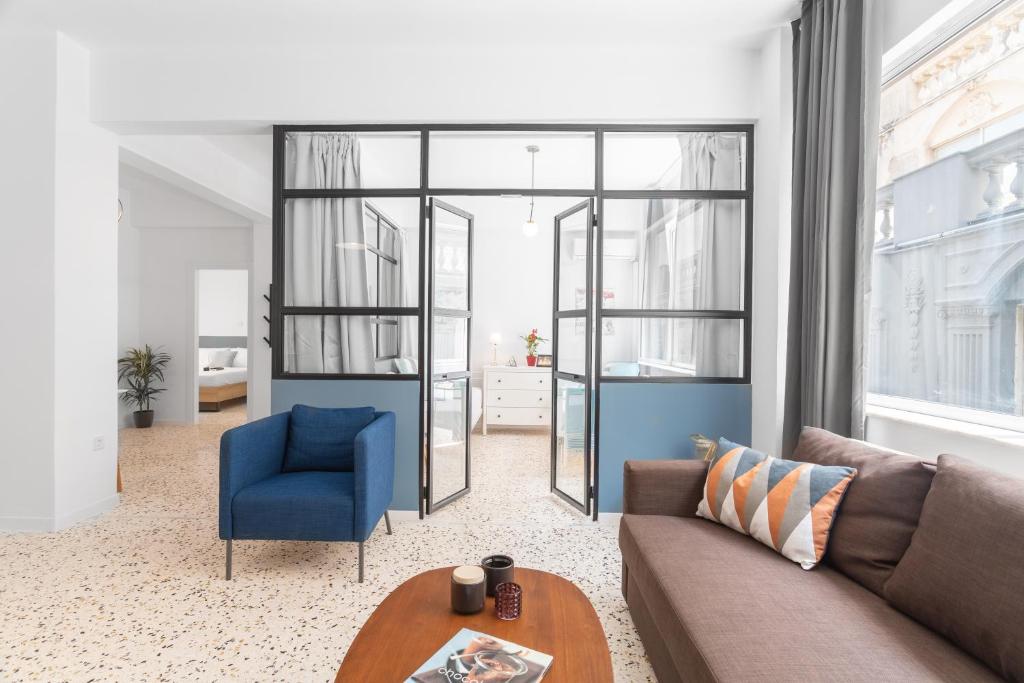 ein Wohnzimmer mit einem Sofa und einem blauen Stuhl in der Unterkunft Downtown Boutique Apartments Acropolis View in Athen