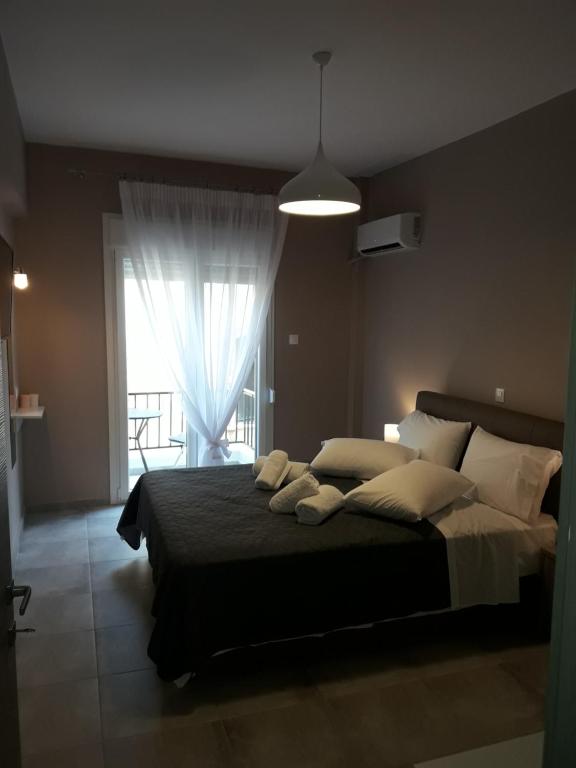 een slaapkamer met een bed met kussens en een raam bij Kalliopi's Guesthouse in Kavala