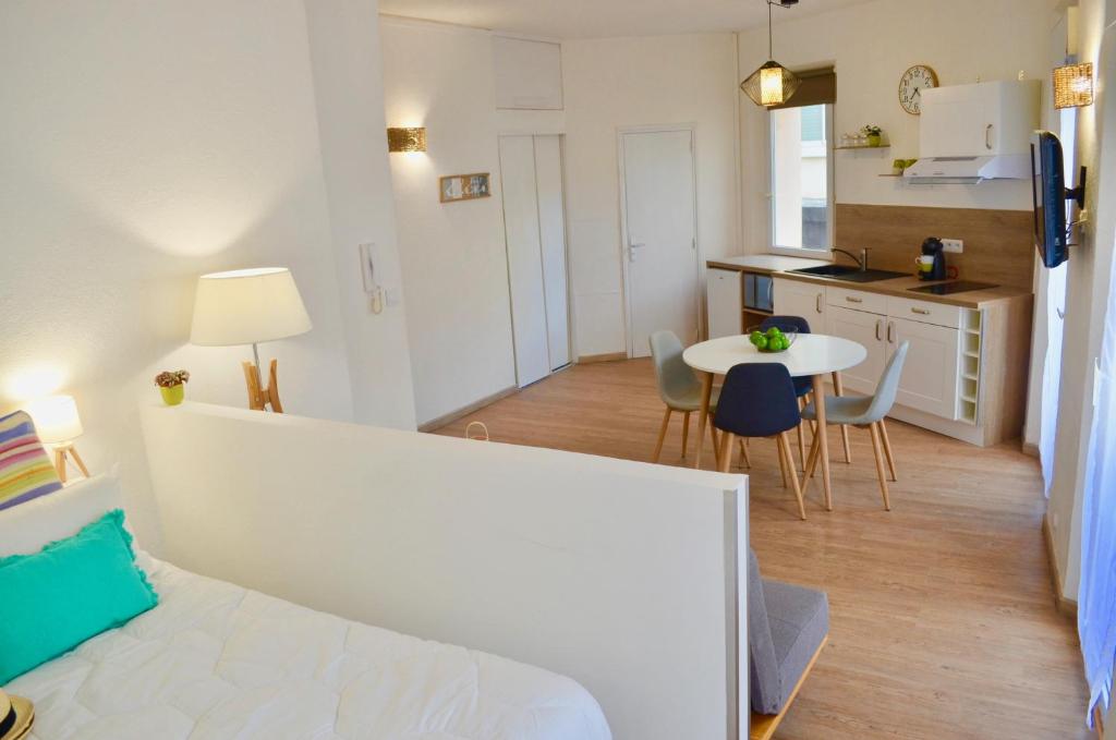 a room with a bed and a kitchen with a table at Studio Liberté Plein Centre in Saint-Raphaël