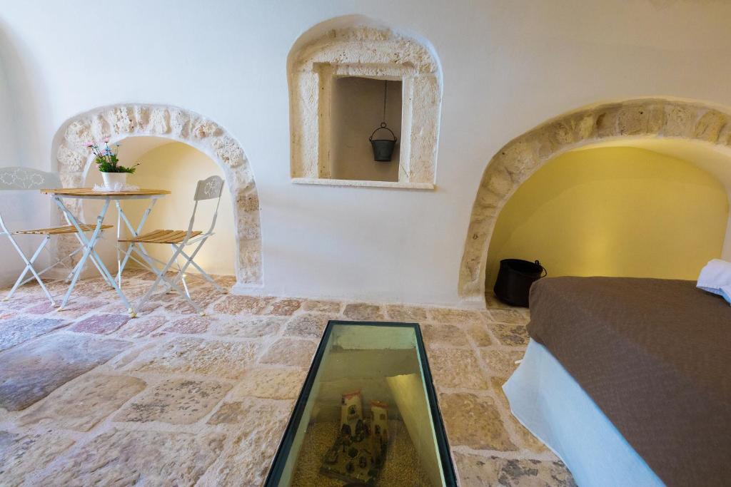 een slaapkamer met een bed en een tafel in een kamer bij Antico Rifugio in Carovigno