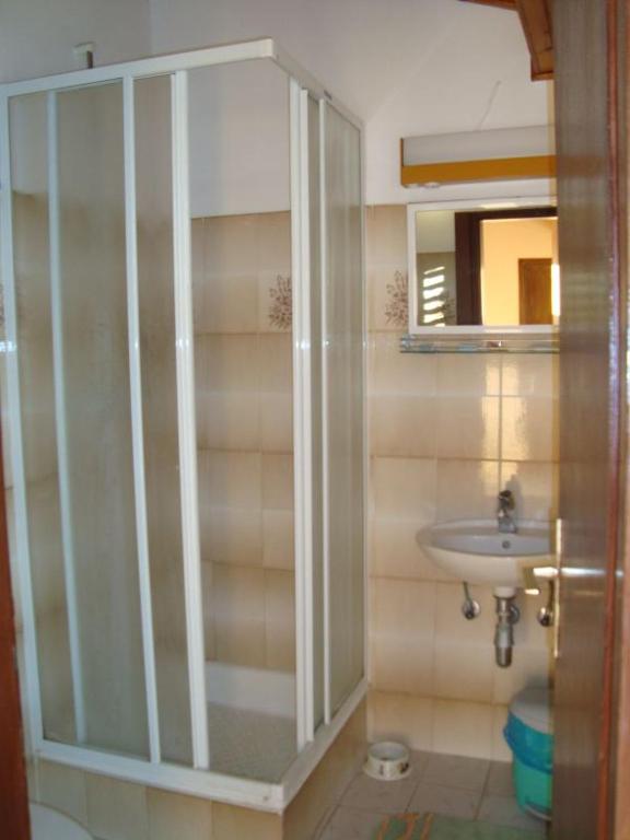a bathroom with a glass shower and a sink at Guesthouse Familija Tariba in Supetarska Draga