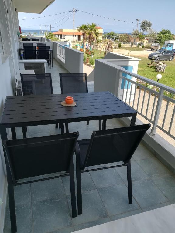 a black table and chairs on a balcony at Seaview Aparthotel in Nea Potidaea
