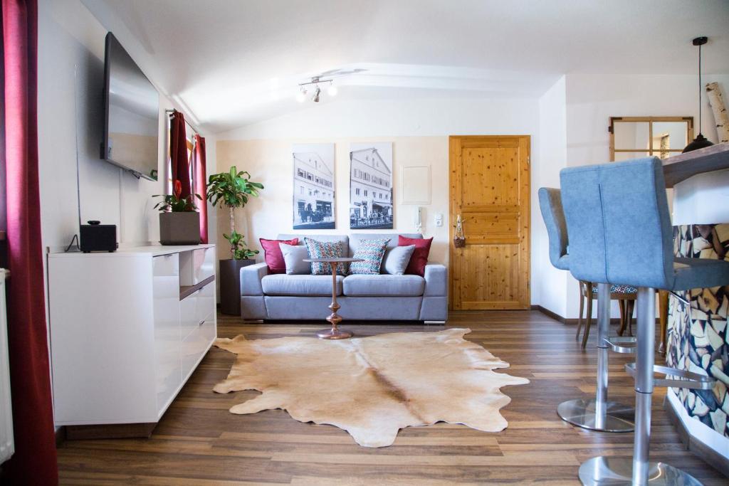 een woonkamer met een bank en een tapijt bij Altstadt Ferienwohnung An Der Stadtmauer in Füssen