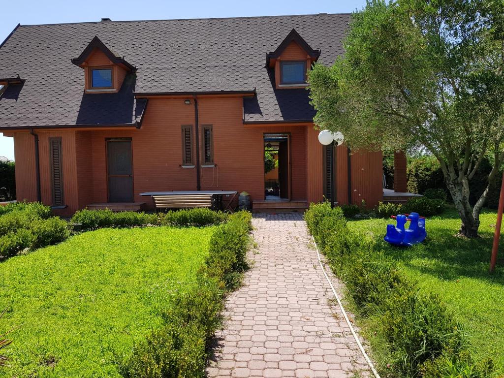 a house with a brick walkway in front of it at Villa "GREEN PARADISE" in Divjakë
