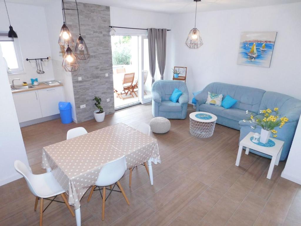 a living room with a table and a blue couch at Apartman Karmen in Tučepi