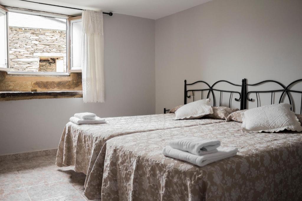 1 dormitorio con 1 cama con 2 toallas en Pension Casa Maruja, en Castromayor