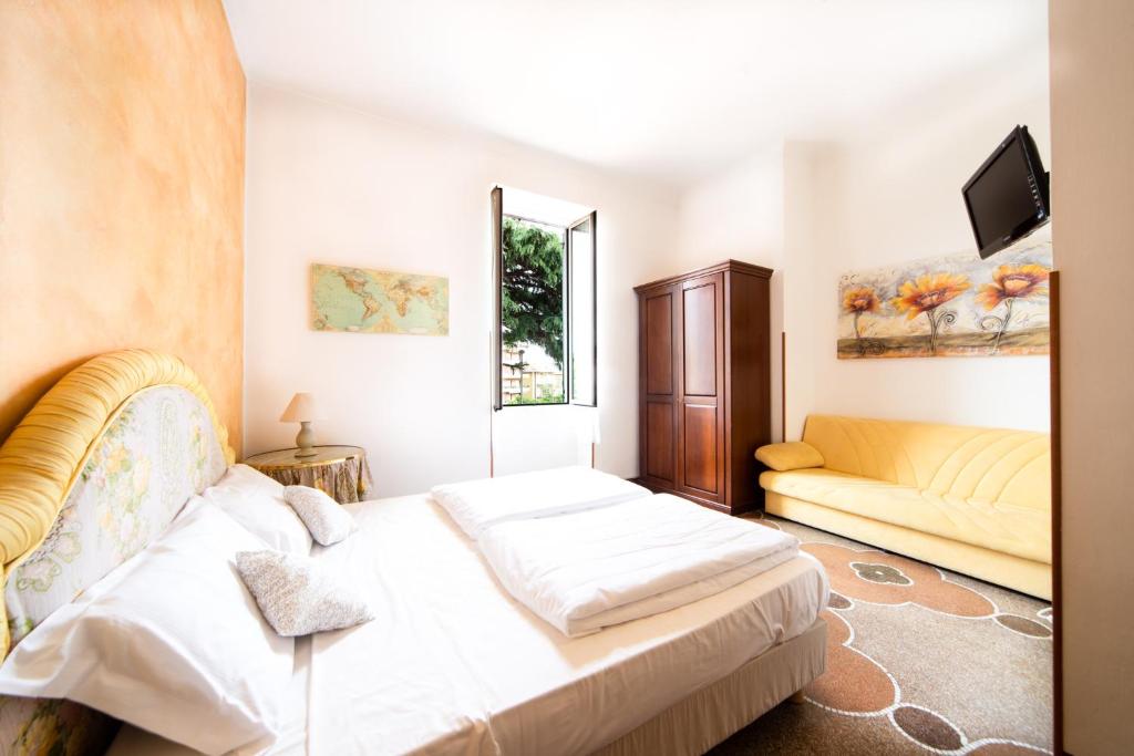 a bedroom with a bed and a couch at Hotel Ristorante Il Caminetto in Diano Marina